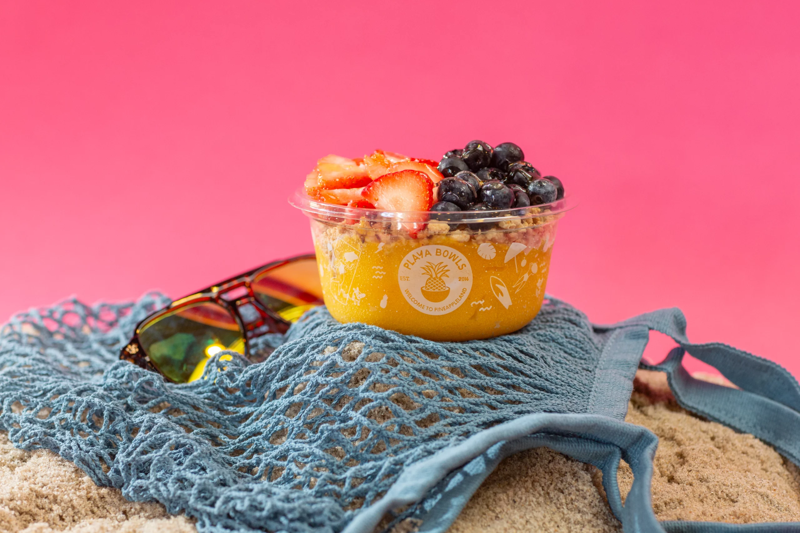 Mango bowl topped with strawberries and blueberries